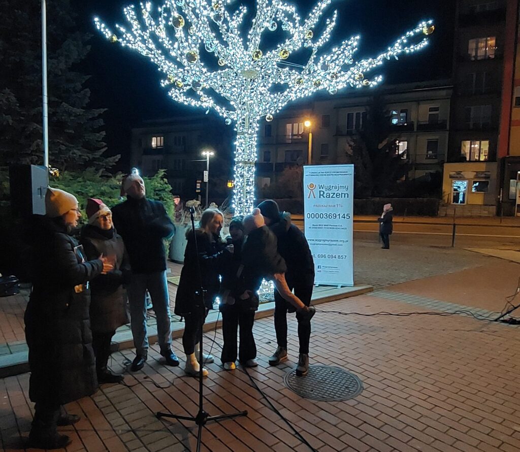 Agnieszka Literacka, Łukasz Baruch, Karolina Żelichowska i mieszkańcy Gołonoga na scenie przed błyszczącym drzewkiem 