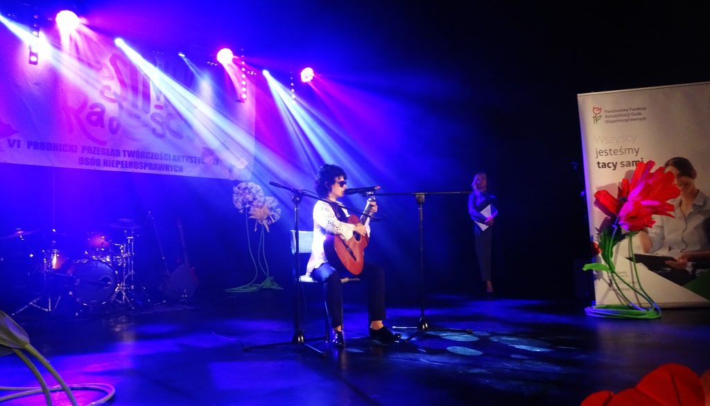 Katarzyna Nowak na scenie - śpiewa i gra na gitarze