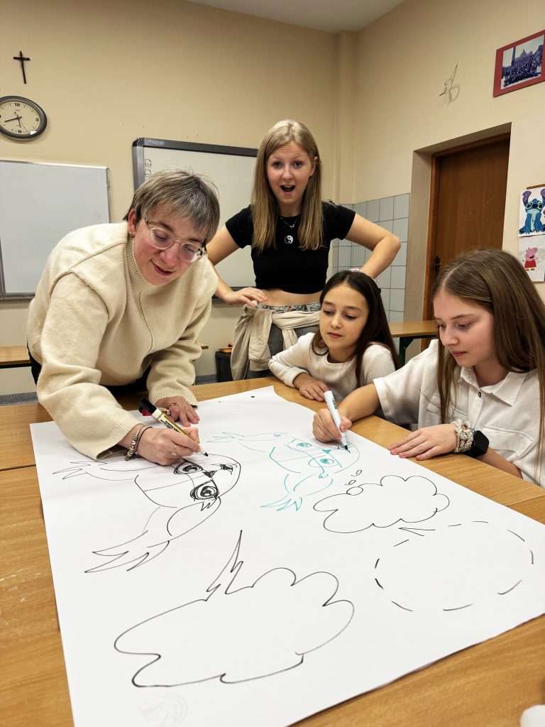 Jedna z wolontariuszek i Justyna rysują na wielkiej kartce.