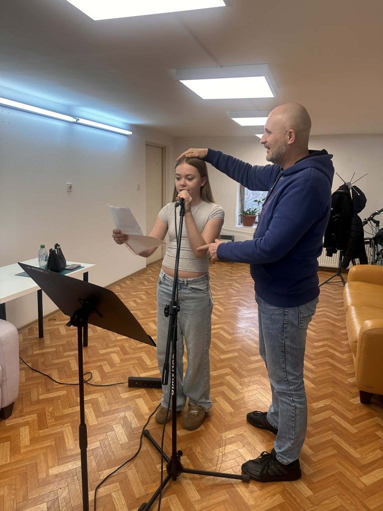 Ćwiczenia z mikrofonem - tu z pomocą służy Łukasz Baruch dla uczestniczki ŚPIEWALNII