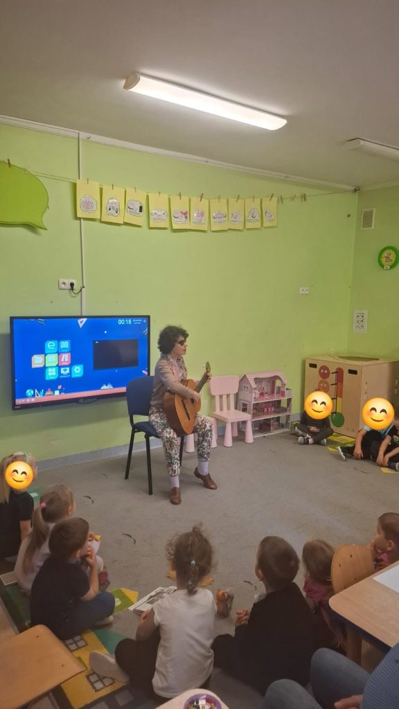 Katarzyna Nowak z dziećmi - ona gra na gitarze.